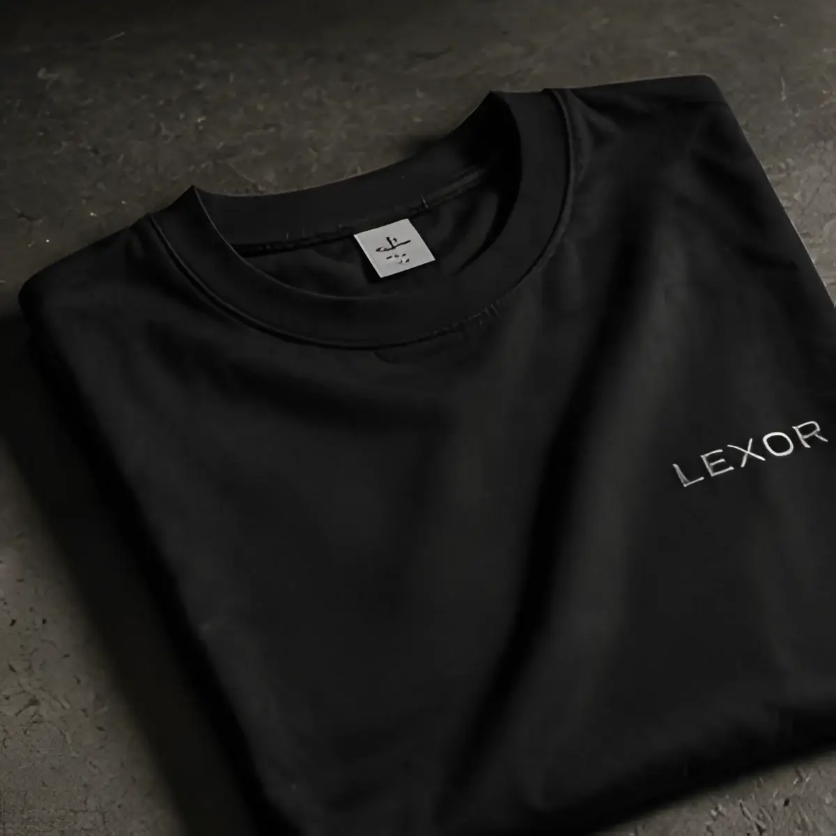 Camiseta de algodón premium negra doblada con el logo en el pecho