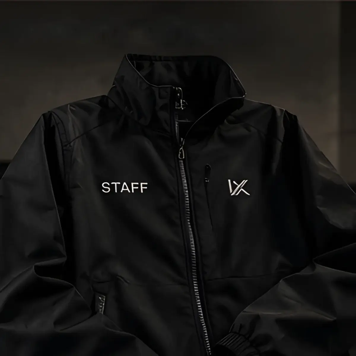 Chaqueta negra de staff con logo en el pecho