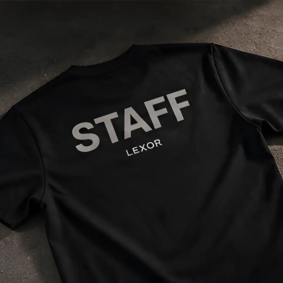 Camiseta negra con la palabra STAFF en la espalda