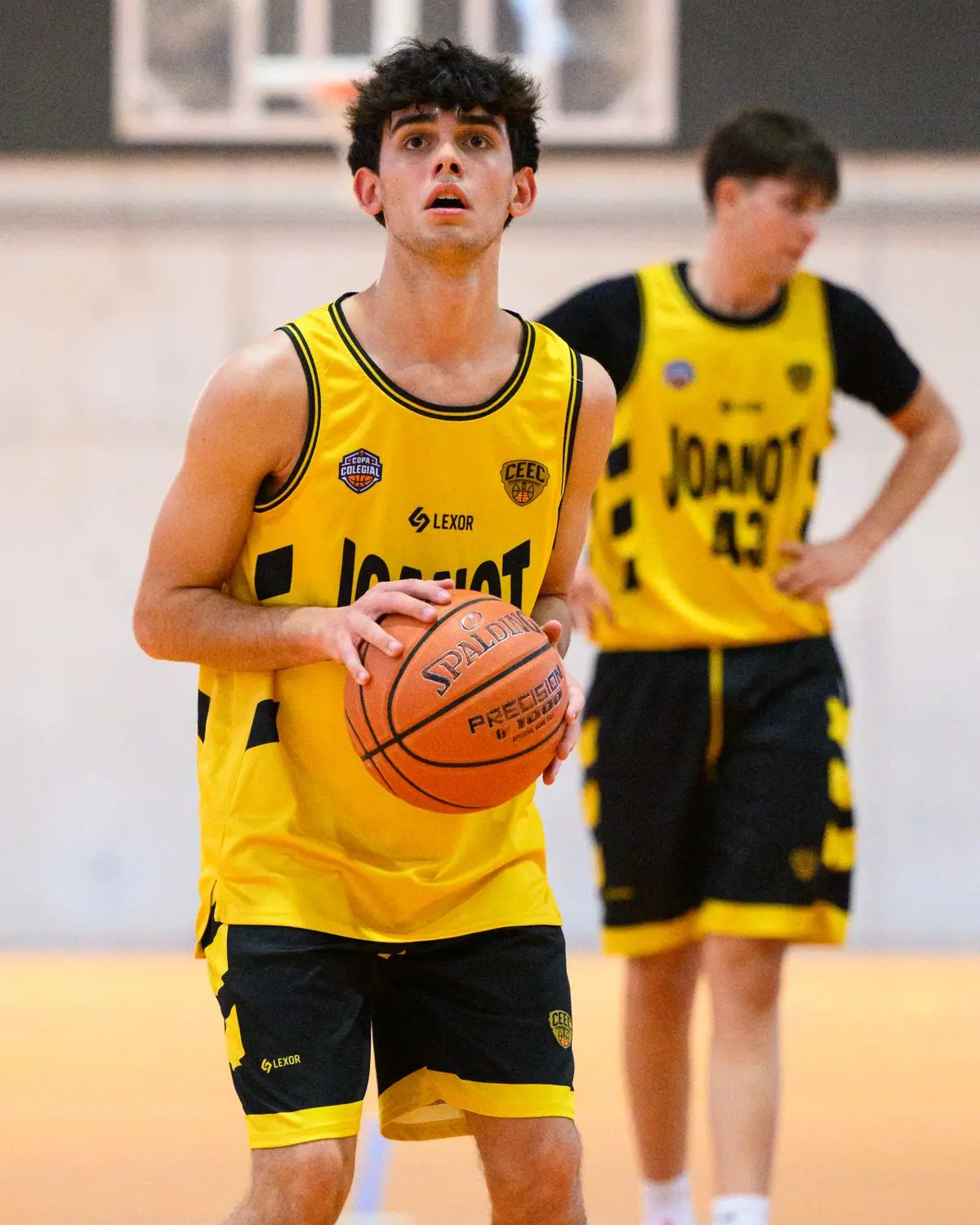 Jugador de baloncesto con la equipación amarilla y negra hecha por Lexor